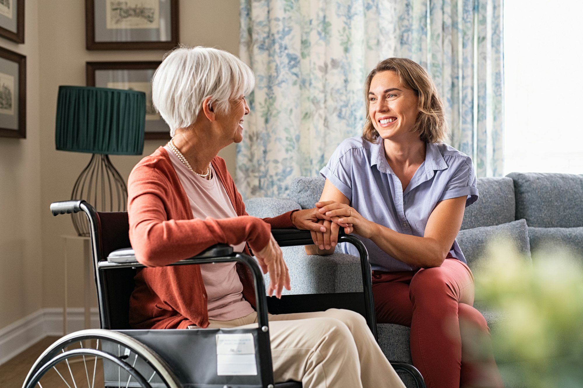 Happy adult woman visiting her elderly mother at home