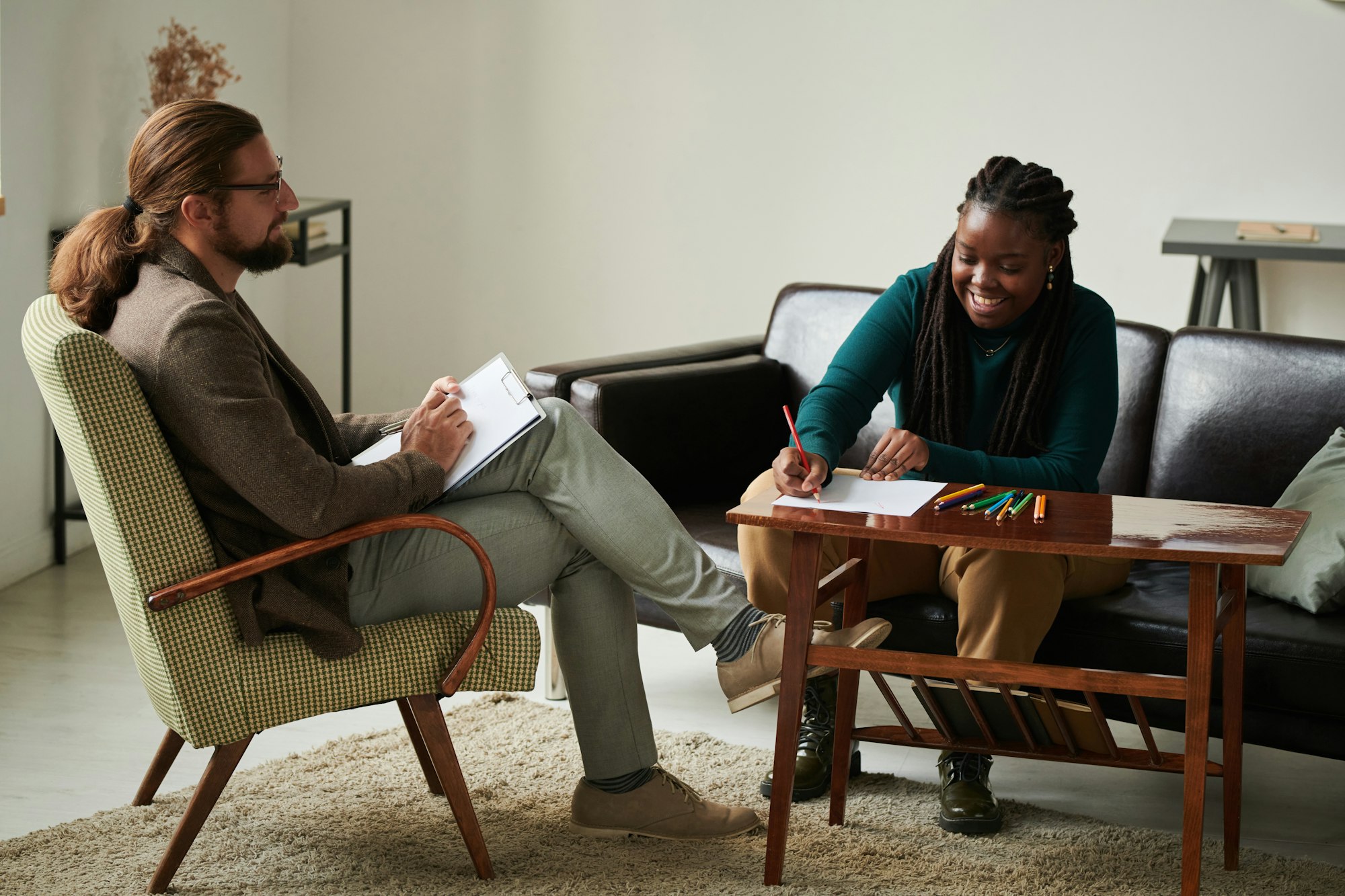 Woman sitting at art therapy with psychologist